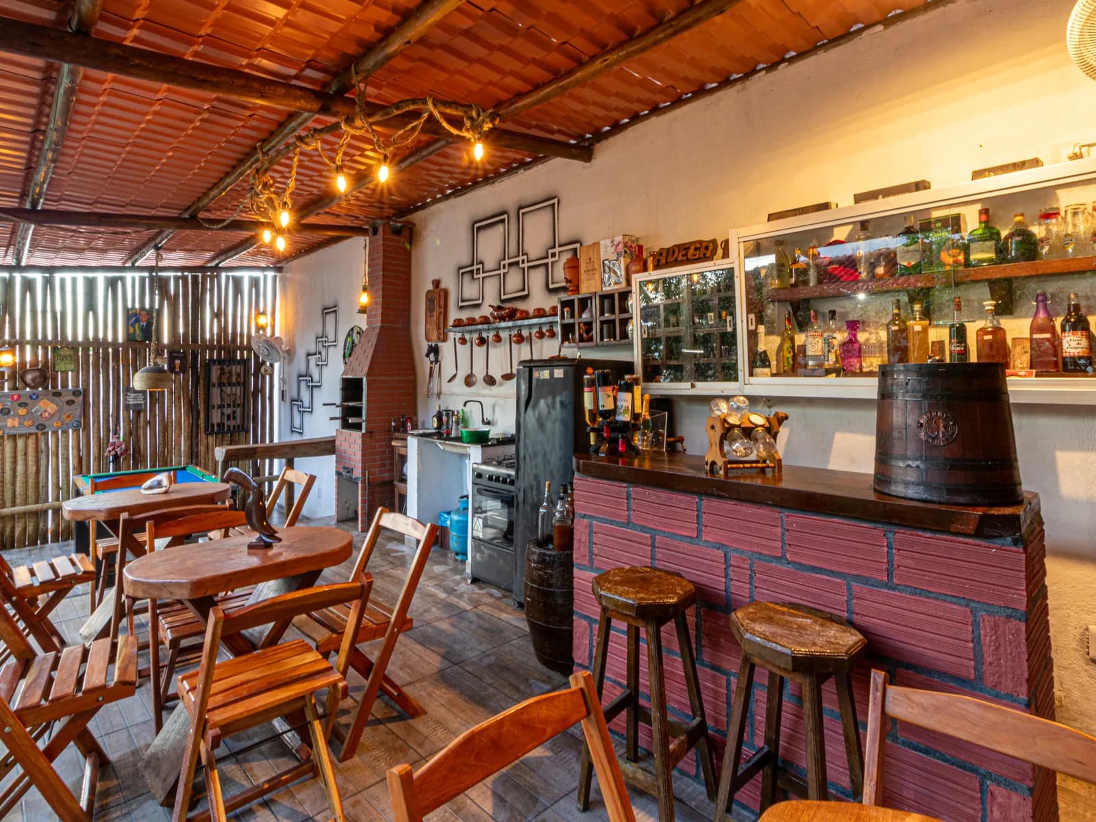 Bar e adega da Casa 1 com mesas de madeira