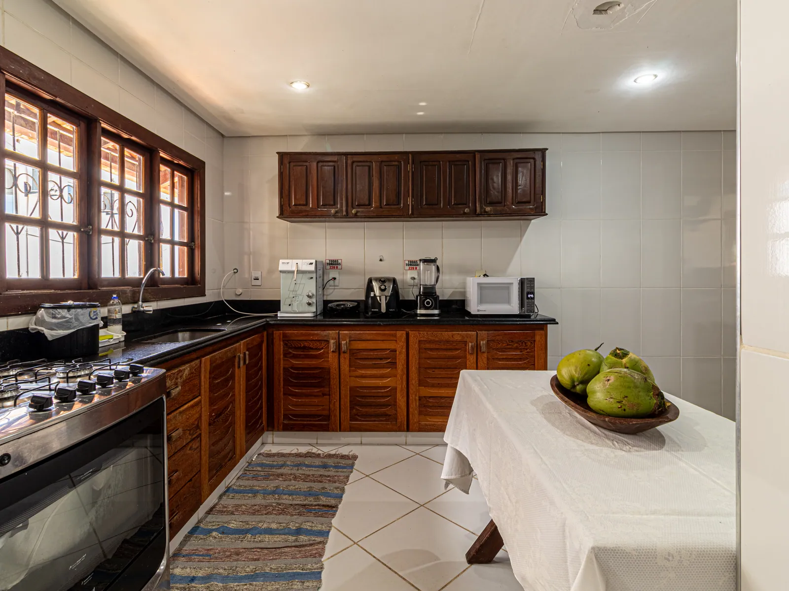 Cozinha equipada da Casa 1 com armários de madeira e bancada ampla