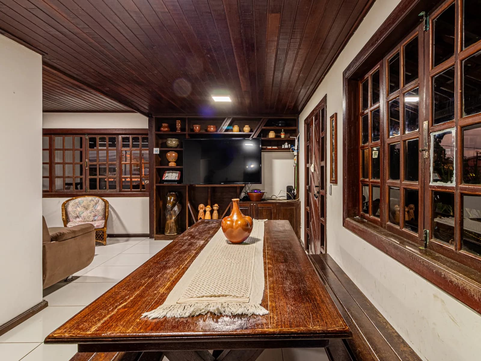 Mesa de jantar de madeira da Casa 1, com lugar para o grupo todo