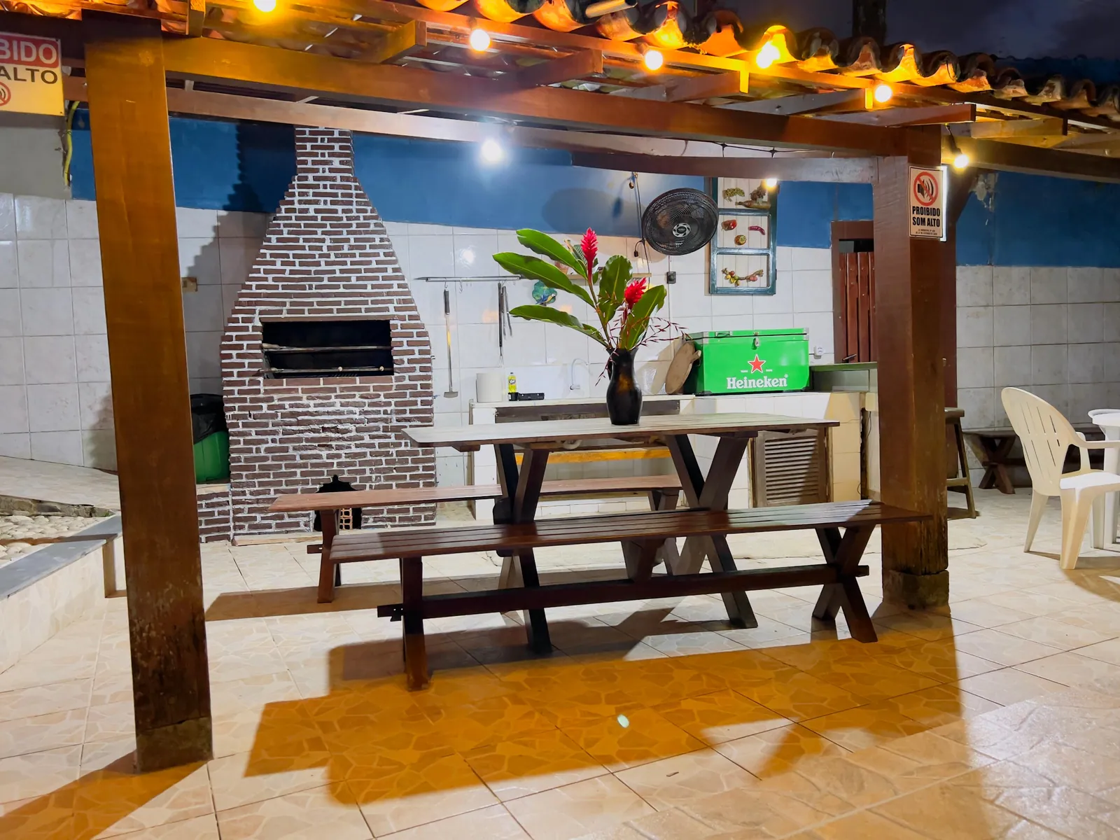 Área gourmet da Casa 2 com churrasqueira e mesa comprida