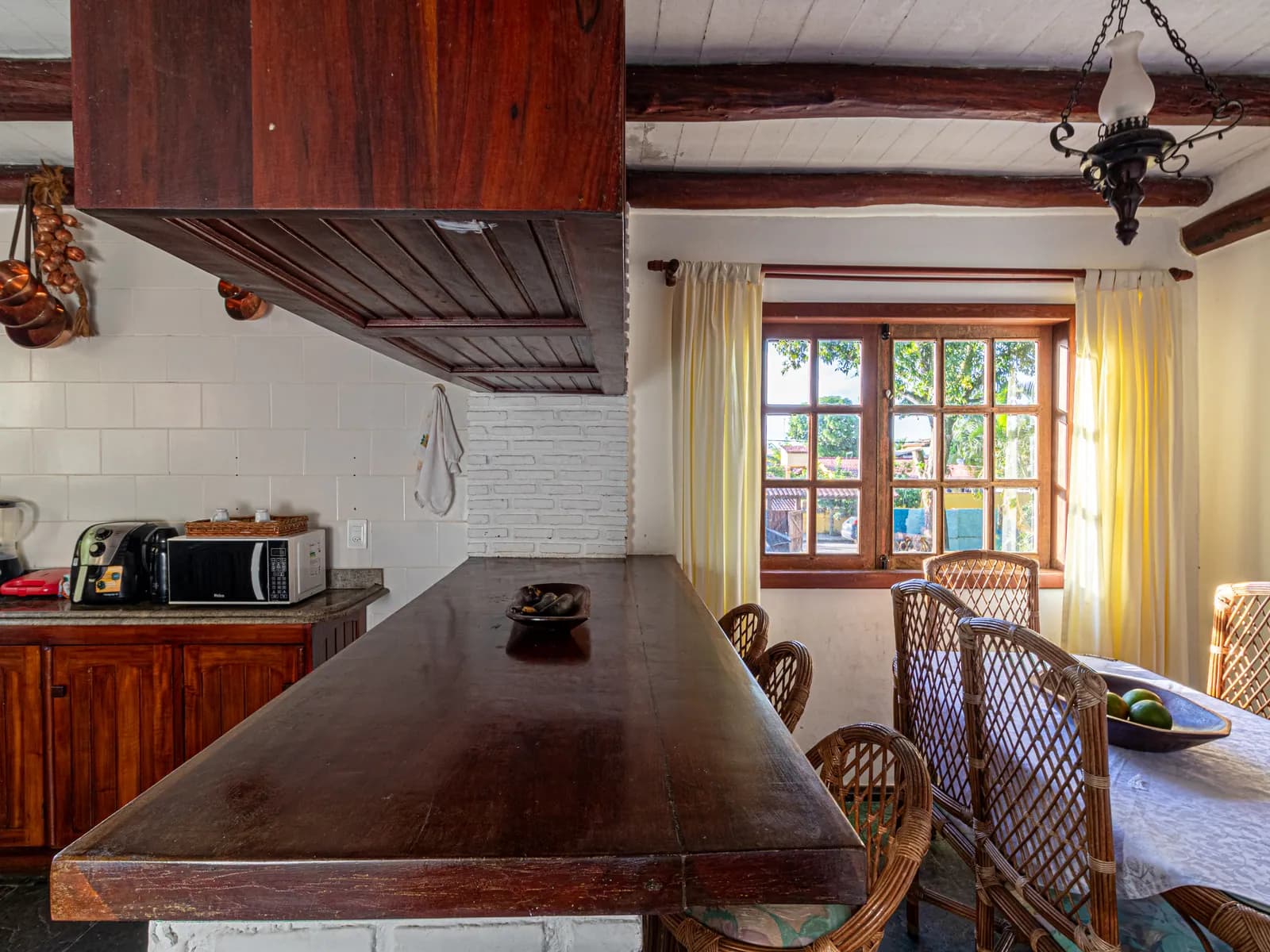Cozinha da Casa 2 com mesa de madeira maciça e armários de madeira