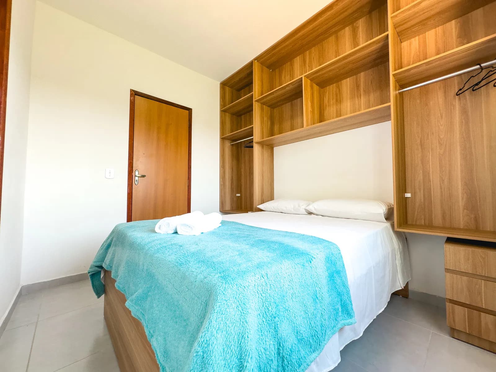 Quarto do apartamento com cama de casal e armário embutido