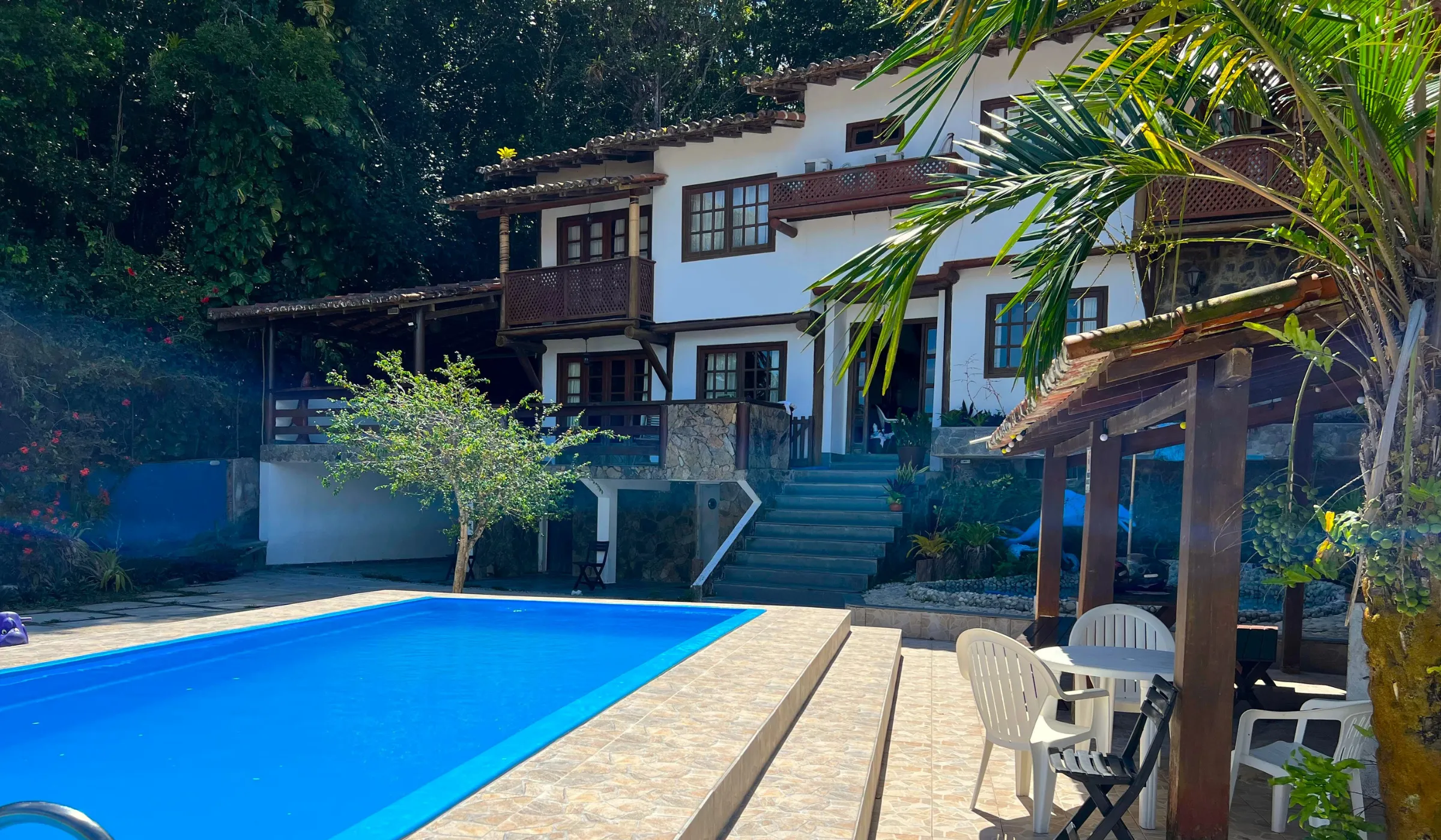 Fachada da Casa 2 com a piscina comprida e o playground no pátio